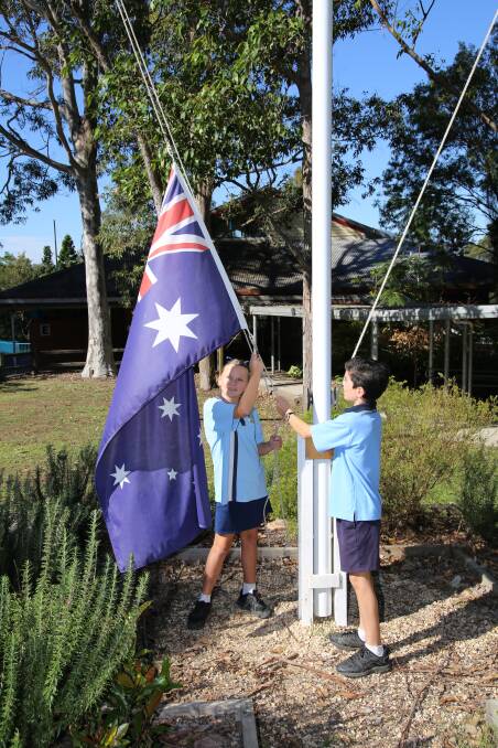 Raising the flag: Imogen and Charlie raising the flag at Kendall Public School, where quality education is provided in an environment where children feel happy and safe.
