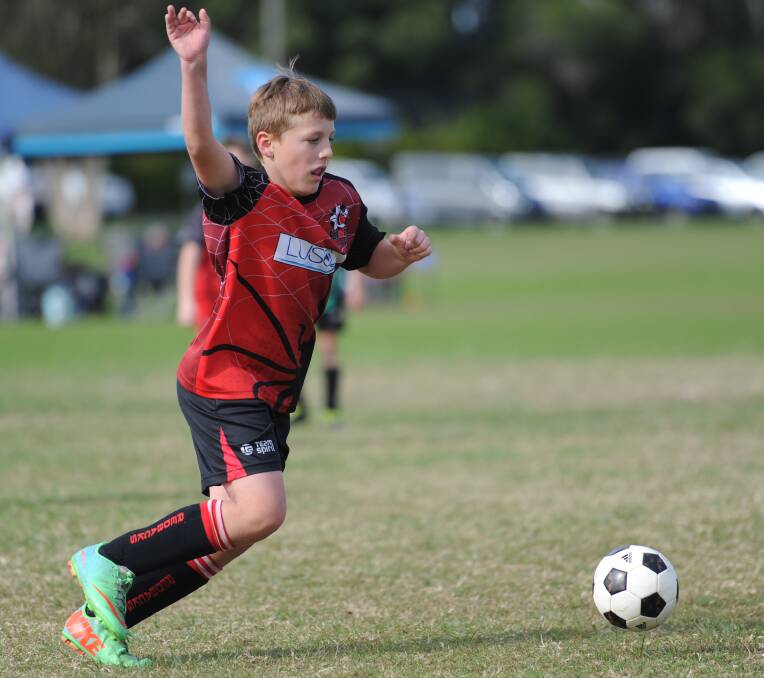 On the ball: Redbacks junior footballer player Austin Bailey balancing as he attempts to control the ball.