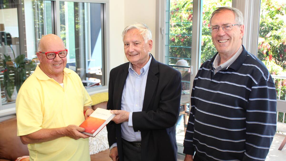 Special gift: Wauchope Hospital Volunteers President Roger Adams accepts a Bible on behalf of palliative care patients from Beechwood Uniting Church's Bill Spence and George Campbell.