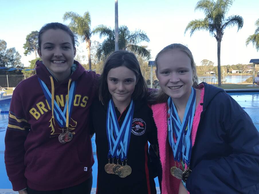 Golden girls: Claire and Sarah McIntosh and Madelaine Goodridge with the medals they earned at the Swimming NSW Multi Class Championships.