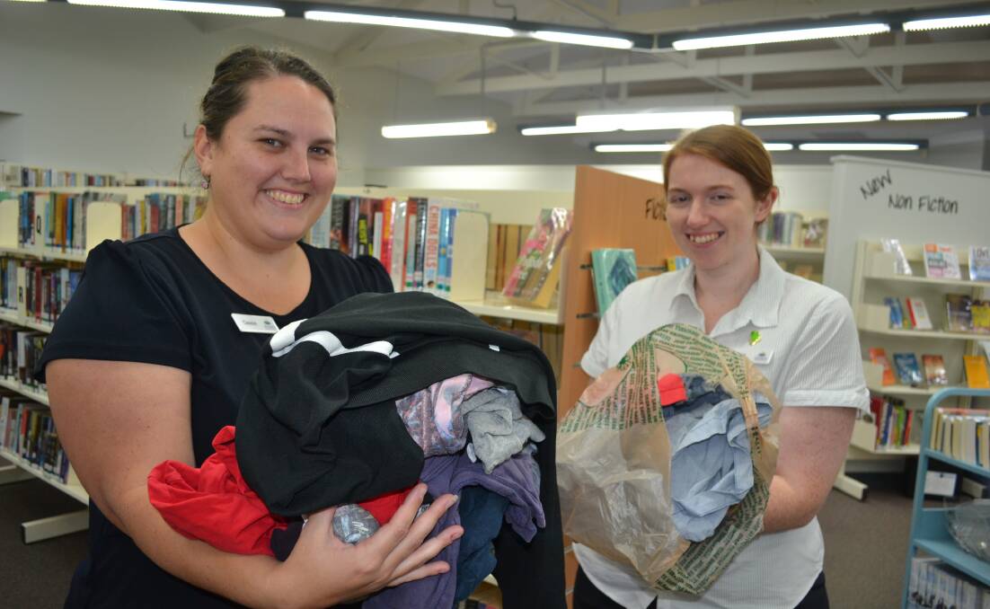 Piles of unwanted clothes: Laurieton librarians Cassie Rowsell and Kia Wood are hosting a Less is More! Declutter workshop at the Laurieton School of Arts Hall on October 10. 