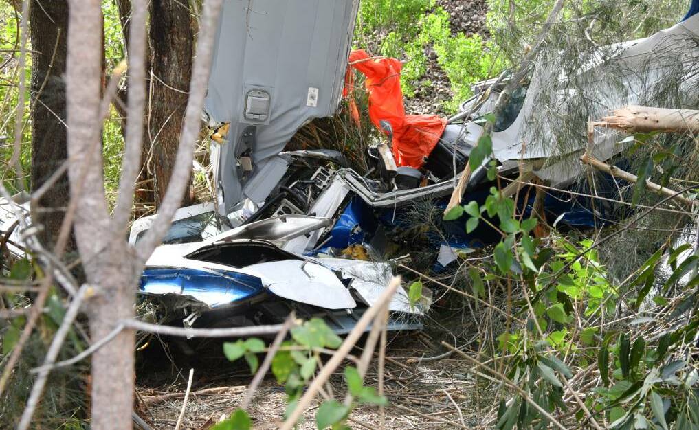 TRAGIC SCENE: The wreckage of the plane beside the Pacific Highway near Johns River.