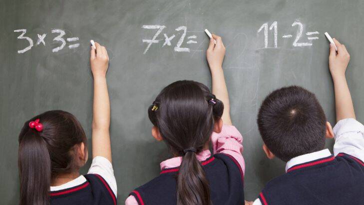 Three school children doing math equations on the blackboard generic pics for independent schools feature