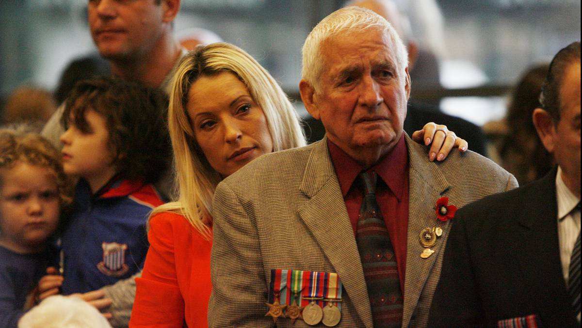 NEWCASTLE: John Daniels is comforted by his daughter Cindy Thompson at Belmont RSL's Anzac Day service. Photo: Ryan Osland, The Newcastle Herald. 