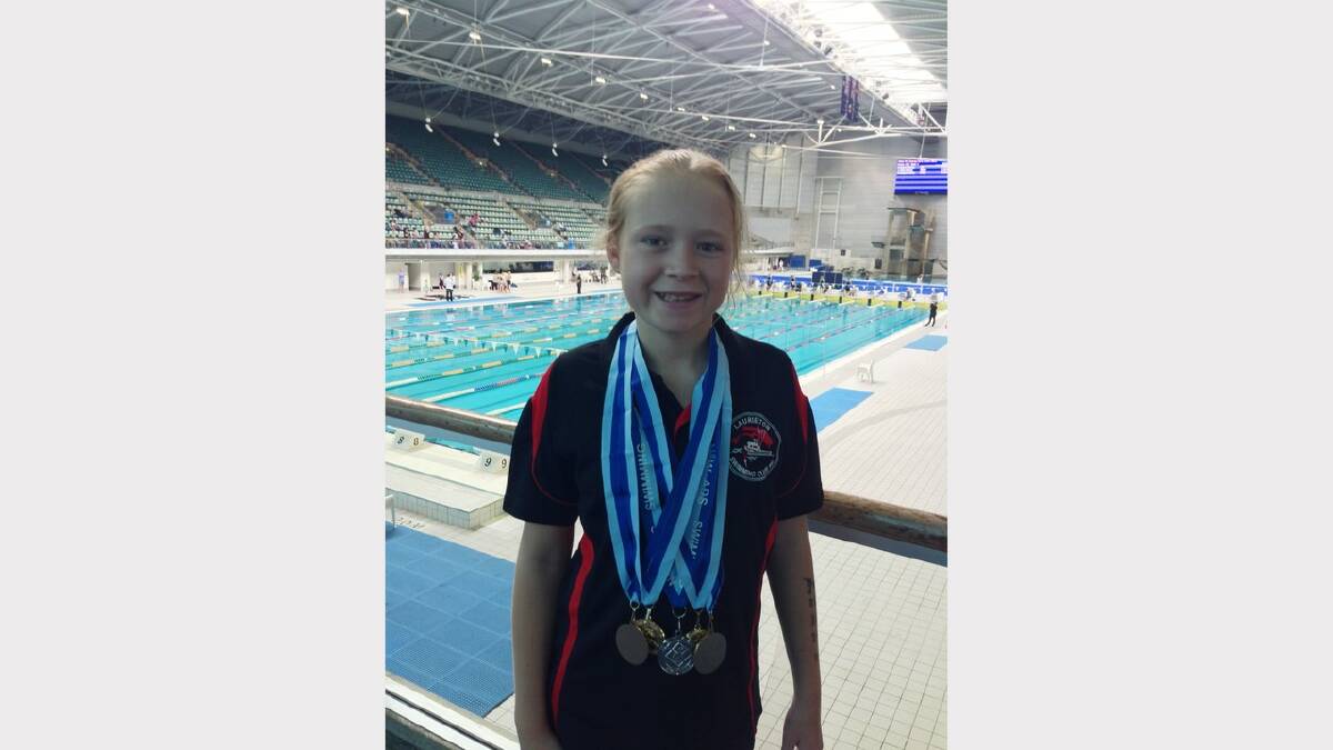 Madelaine Goodridge of Laurieton with just a handful of her swimming medals.