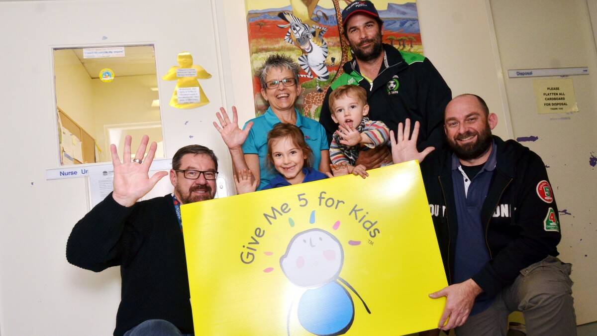 High five: Radio 2MCFM’s breakfast announcer Mark Strachan, pediatric unit manager Cheryl Nolte, parent Simon Filipek with children Teal and Miekah and fundraiser coordinator and afternoon announce Niko give a high five to the community for its help raising more than $50,000 for specialist equipment for Mid North Coast hospitals.