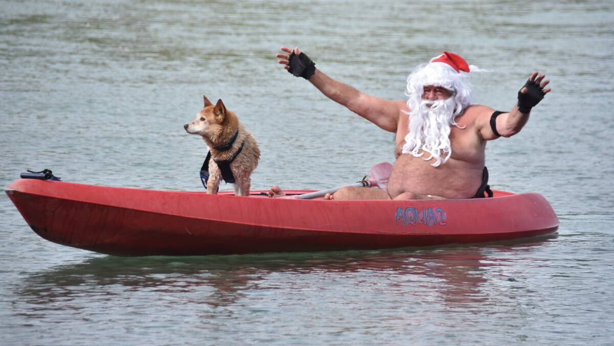 HE'LL BE BACK: Santa, Ron Hunter, and Spike will be back in the kayak on Lake Cathie on Monday.