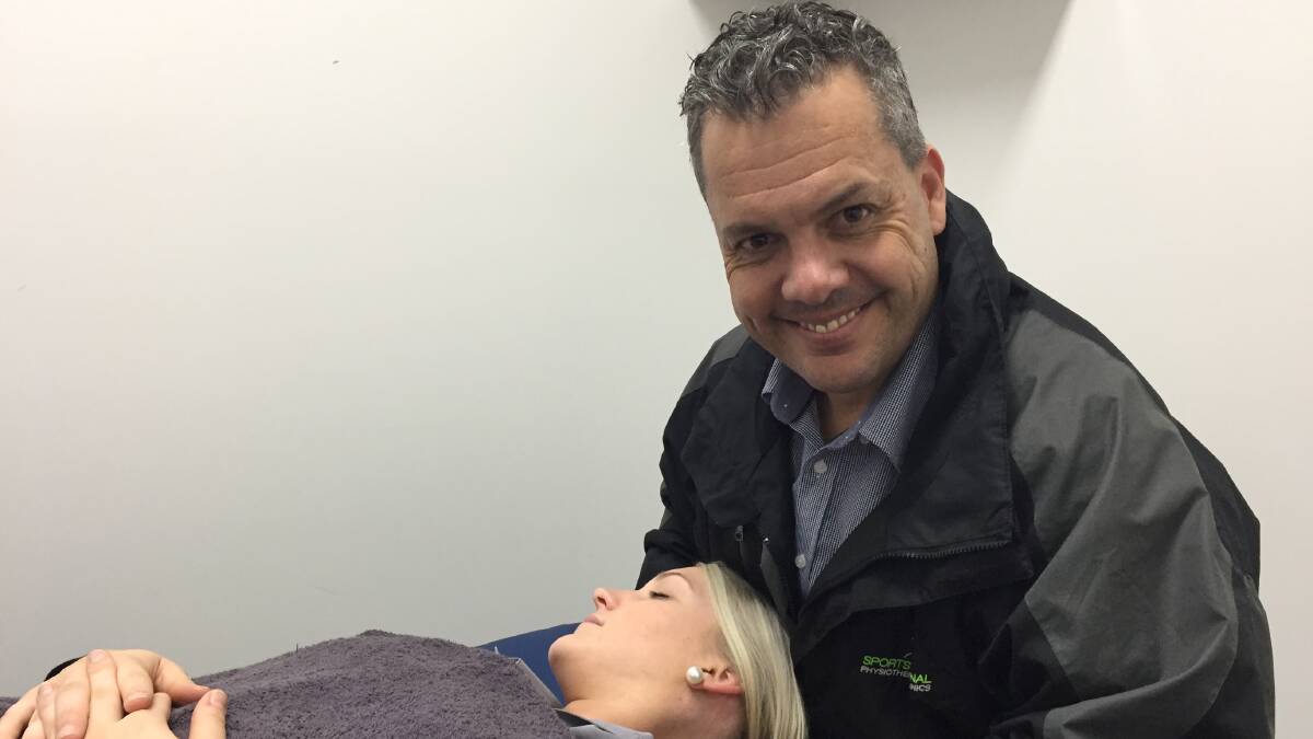 End in sight: Dean Lawler demonstrates headache treatment techniques on Bec Russell. Headache suffers are urged to attend a free information night.