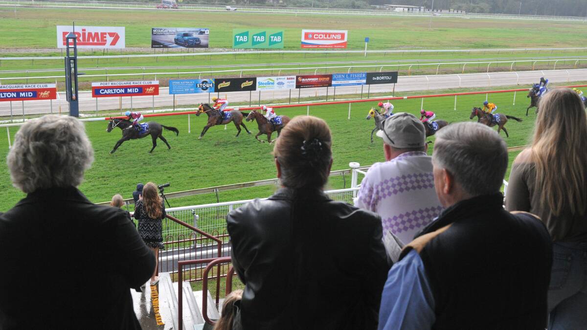 Cheering em home: The crowd watches one of the race finishes leading up to the main event at the Port Macquarie Racetrack.