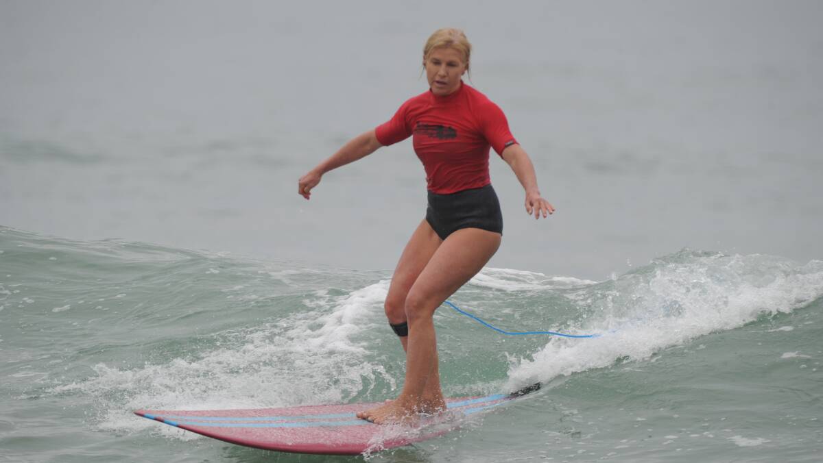 Catching a good one: Liz Dene competes in last year's Better Homes Over 45s long board. Photo: Matt Attard. 