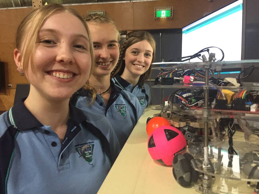 Robots: Ebony Nicholas, Elizabeth Legge and Shae Bradford with their football-playing robots.