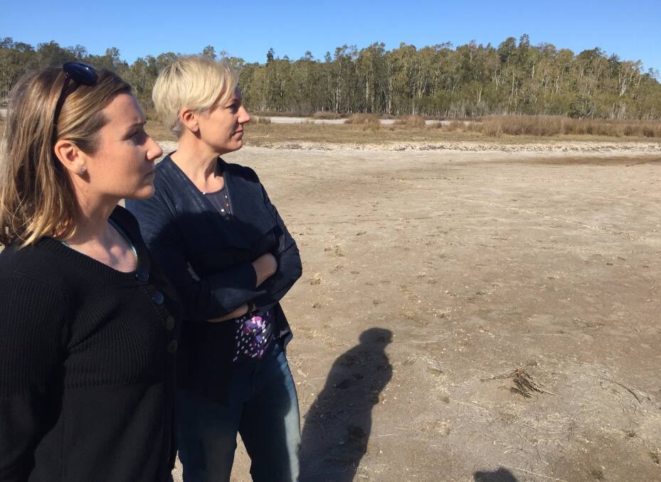 Dried out: Greens member Lauren Edwards and the Greens' Upper House environment spokesperson Cate Faehrmann inspecting the Lake Cathie lake on Wednesday.