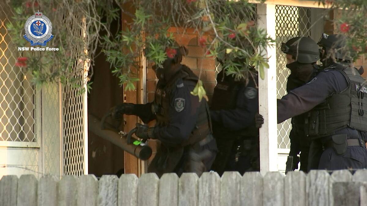 Raid: NSW Police converge on an East Kempsey home as part of a series of raids in Kempsey and Port Macquarie. Photo: NSW Police