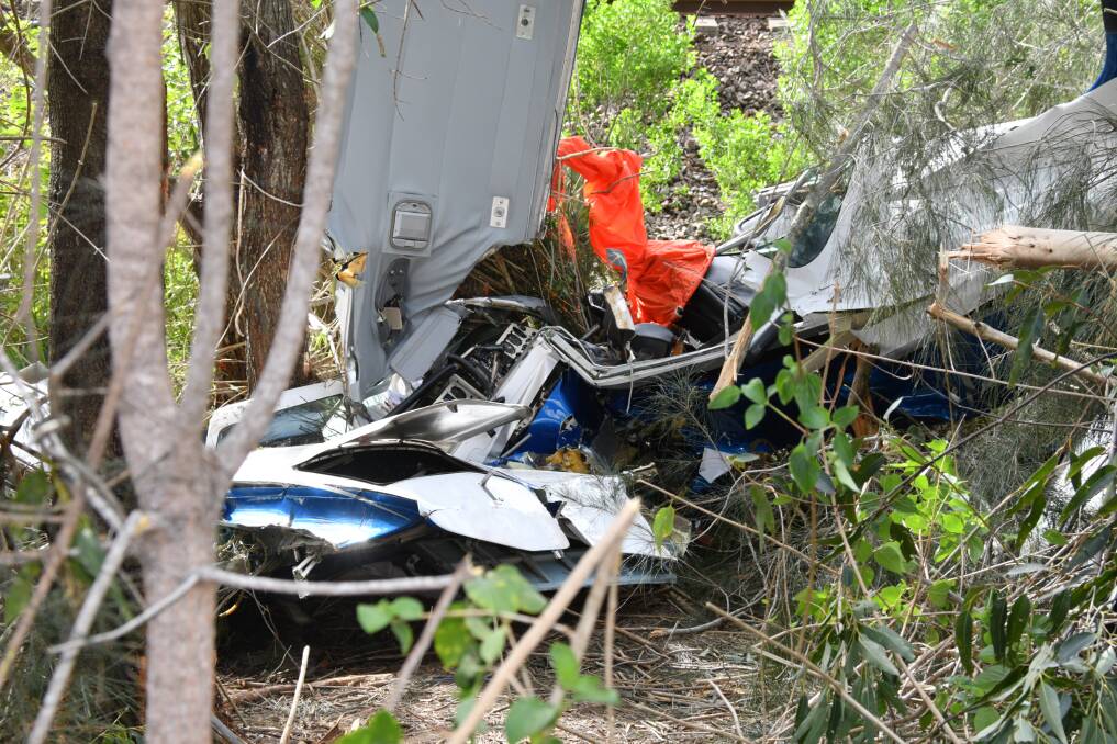 TRAGIC SCENE: The wreckage of the plane beside the Pacific Highway near Johns River.