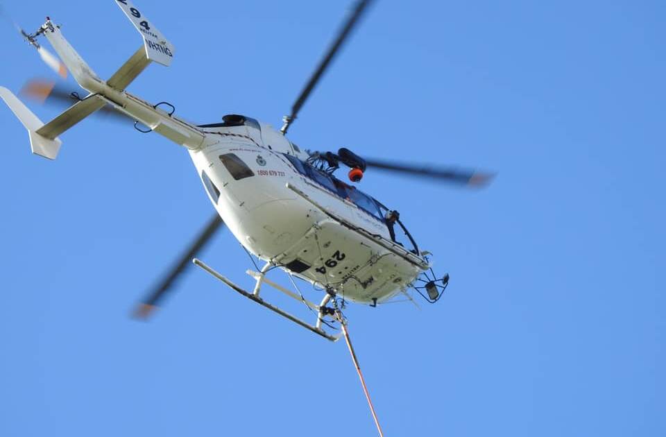 A helicopter scoops up water from the Hastings River in Wauchope. Photo courtesy of Sue McDonald.