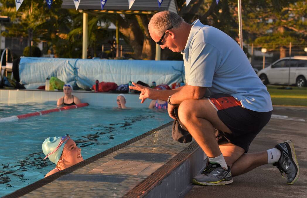 That's twice: Michael Mullens offers some advice to senior swimming squad member Taylor Sargeant. Photo: Paul Jobber