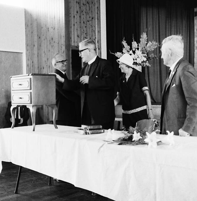 Thank you: Archdeacon Warr is presented with part of the cedar bedroom suite gifted to him by parishioners on his retirement, 1969. Photo from Port Macquarie Museum.