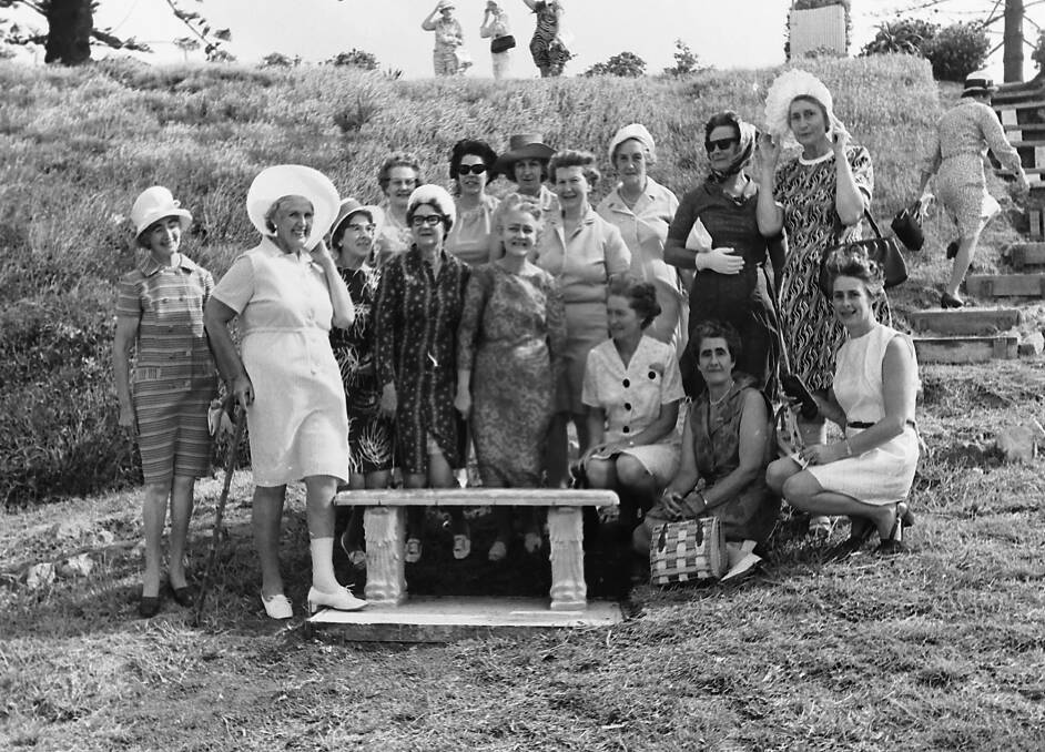 Take a seat: Quota women gather around the seat they donated to Mrs Yorks Garden in the windmill-waterfall section, 1970.