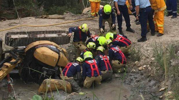 Firefighters work to free Daniel Miller from the dam at his property in Charlotte Bay. Photo: Facebook/Saimaa Miller
