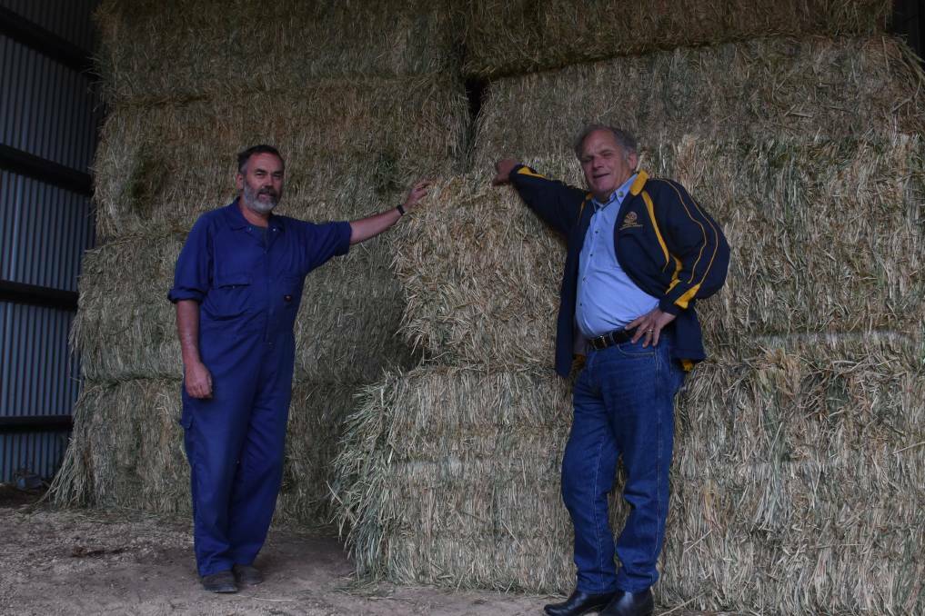 LIFELINE: Hastings dairy farmer Bob Baker and Wauchope Rotary's Reg Pierce with some donated hay. PHOTO: Laura Telford.