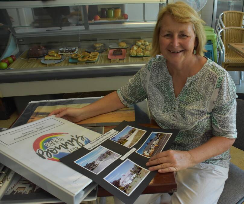 Celebrating history: Kathy Regan views the collection at cafe Crave in Bonny Hills. It is hoped the collection will continue to expand as more people locate photos and recall special times.
