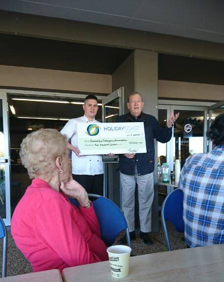Generous donation: Oasis by the River restaurant manager Brendon Lynch hands the $2000 to chairperson Camden Haven Community @ 3 chairperson Theo Hazelgrove. Photo: supplied. 