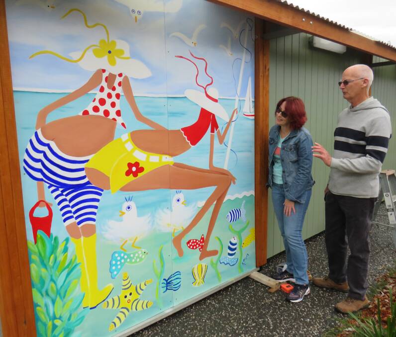 Back in colour: Kim Mclean's artwork has been reinstalled at the Bonny Hills amenities block. Admired here by Mrs Mclean and Roger Barlow from the Bonny Hills Progress Association. 
