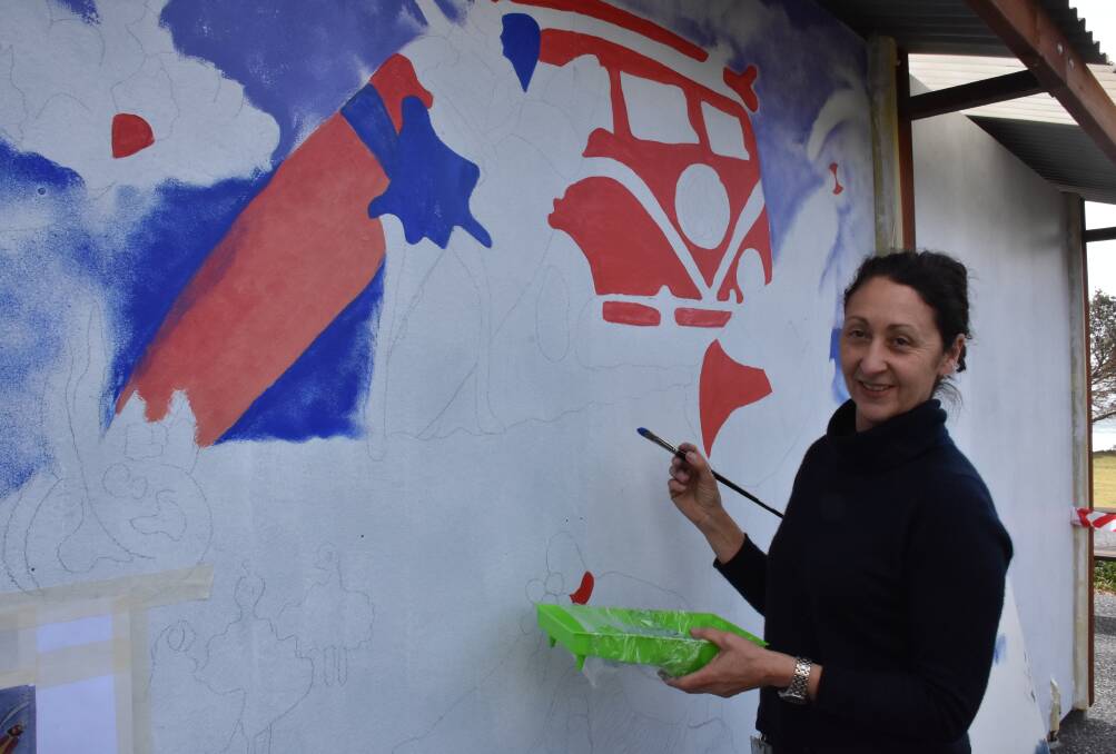 Intricate work: Lucy Pascale is painting the winning mural design onto the amenities block at Rainbow Beach, Bonny Hills. 