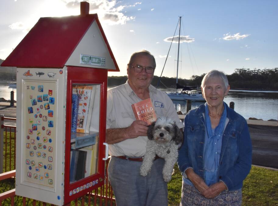 Laurie Wickings, dog Floss and Elizabeth Wickings stand at the street library situated at 56 The Boulevarde, Dunbogan. 