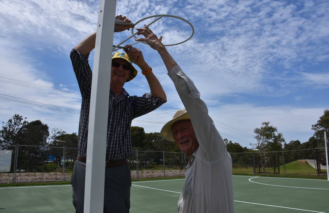 Bonny Hills Progress Association president Roger Barlow and Ian Simpson work on putting the netball hoop up. 