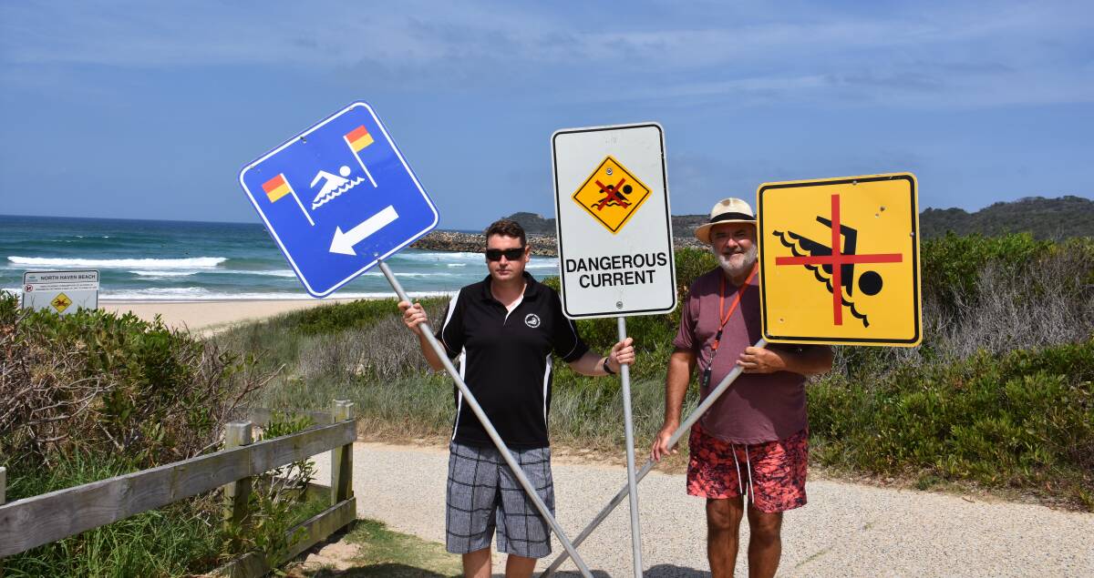 Important education: Camden Haven Surf Life Saving Club vice president Ben Hosick and member Phil Hogan hold up signs at North Haven Beach. An educational community presentation is on Saturday, February 24. 