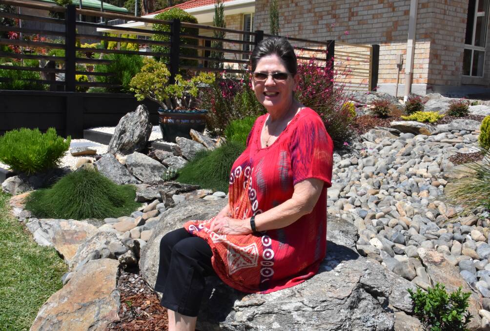 Judy Giles sits at the front of the Japanese style garden at Lakewood.