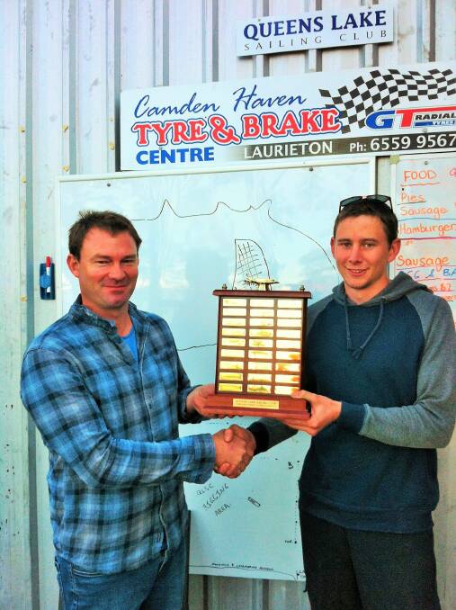 Queens Lake Sailing Club Commodore David Castleton (left) presents the Points Score trophy to winning sailor Cameron Kaul. Photo: supplied. 