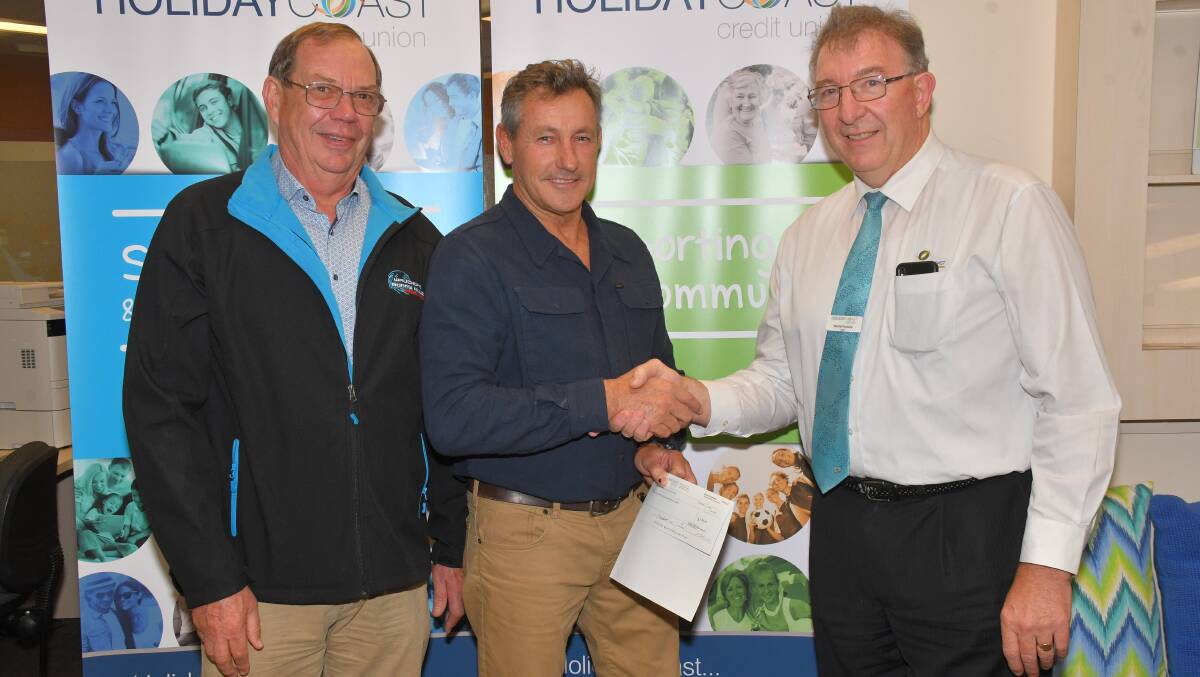 Wauchope Bonny Hills SLSC members Phil Kaufmann and  Steven Monaghan accept the grant from Holiday Coast Credit Union CEO Neville Parsons.