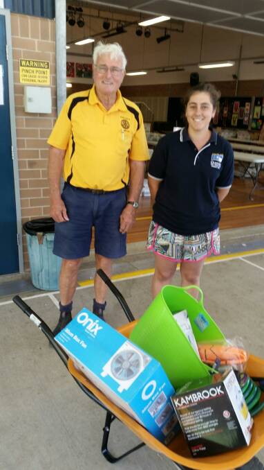 Rotarian Alan Anderson with raffle winner Natalie Young and the wheel barrow.