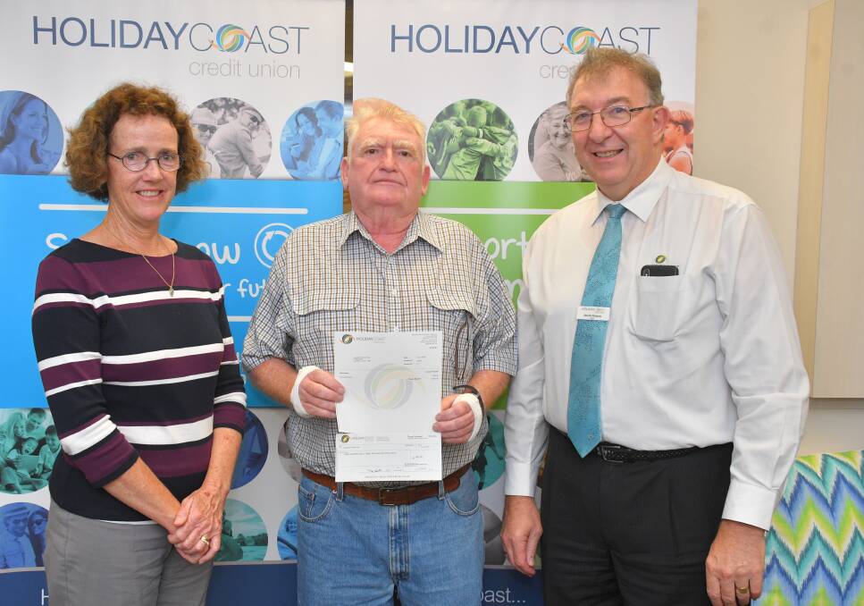 Laurieton Tennis Club's Marion McIntosh and president Peter Trotman accept the grant from Holiday Coast Credit Union CEO Neville Parsons.