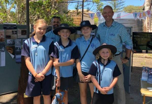 Johns River Public School students Elkie, Phoenix, Ellie and Indigo give up their Saturday to attend Johns River markets (in school uniform). Back row teacher Mr Josh Tomasone and Relieving Principal Mr Murray McGrath