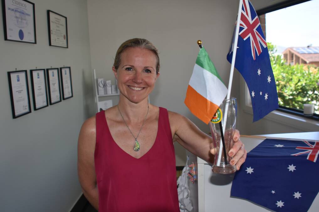 NEW AUSTRALIAN: Kendall business owner Genevieve Hoare with a VB glass and flags.