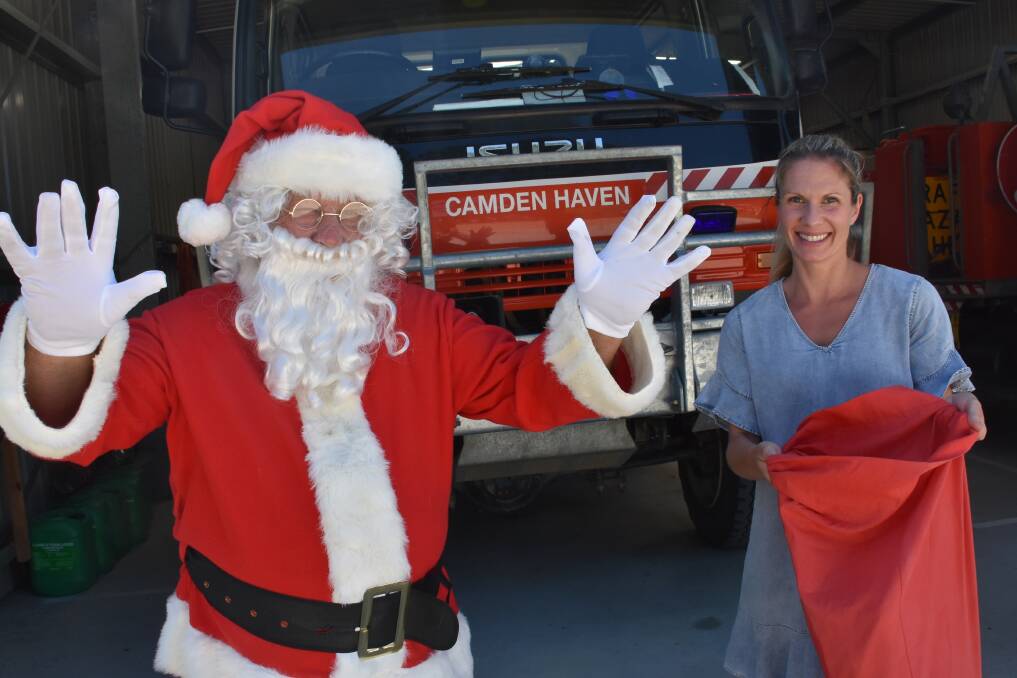 SANTA IS ON HIS WAY: Santa (fire captain Ron Morris) and Chamber of Commerce rep Holly Lambert.