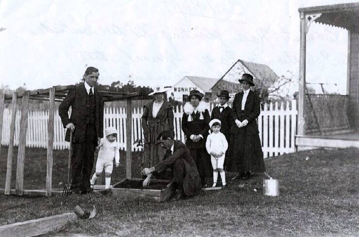 Ernest Rose plants his memorial tree on August 19, 1916,  outside the family's Robertson-Rose General Store on Laurie Street. Pictured left to right are Harry Robertson (Tree committee secretary), his son Angus Robertson, unknown woman, Ernest Rose having just enlisted in the AIF, Olive Robertson (Harry's wife) with her son Jack Robertson and two unknown women.
