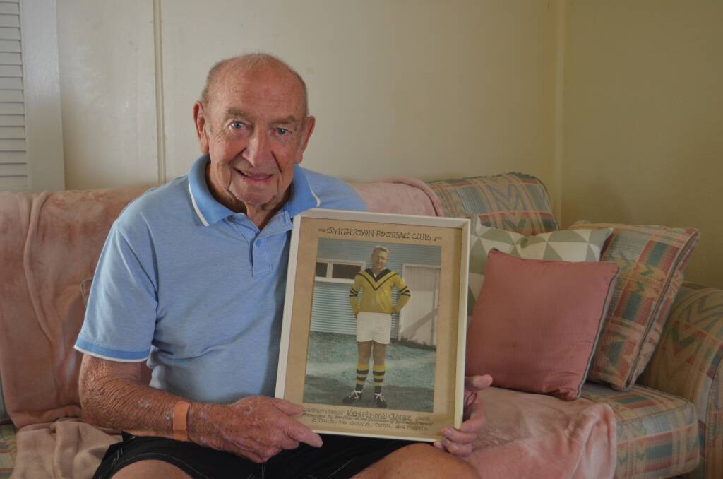 Ken 'Snow' Clarke proudly holds a photo of himself in his glory days for his beloved Smithtown Tigers. Photo: Callum McGregor